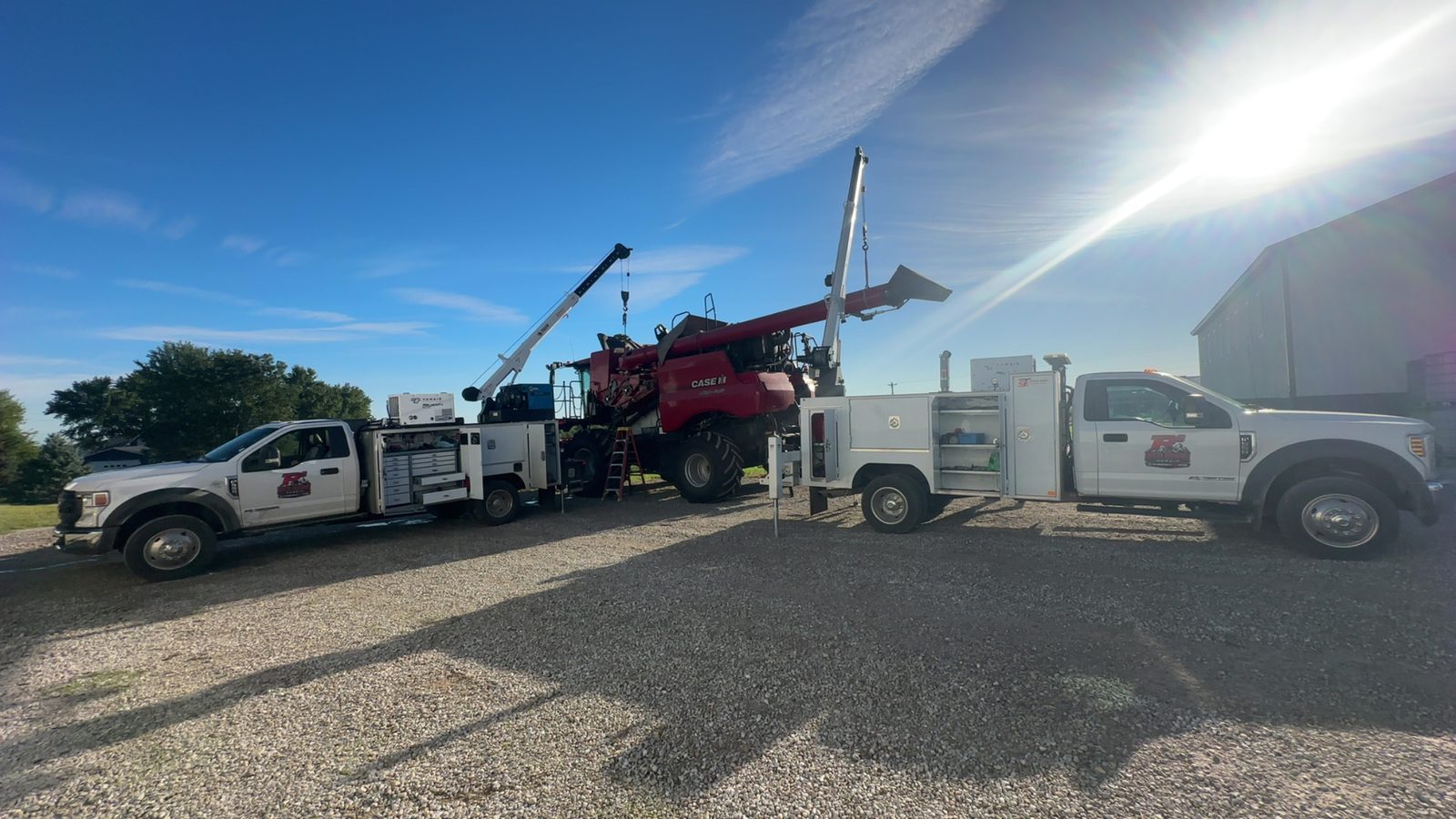 Two Red Ridge Repair mobile service trucks working on a combine harvester in Ohio